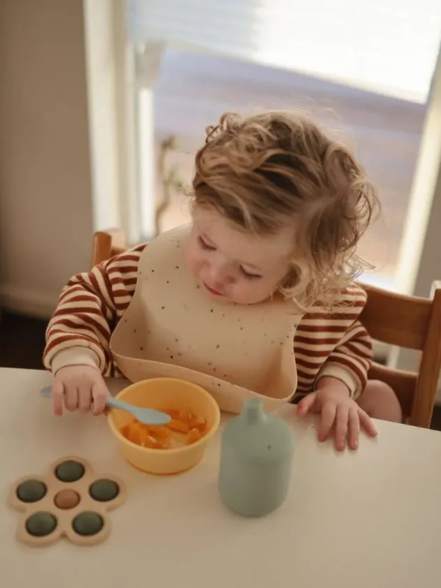 Mushie - śliniak silikonowy z kieszonką Vanilla Confetti