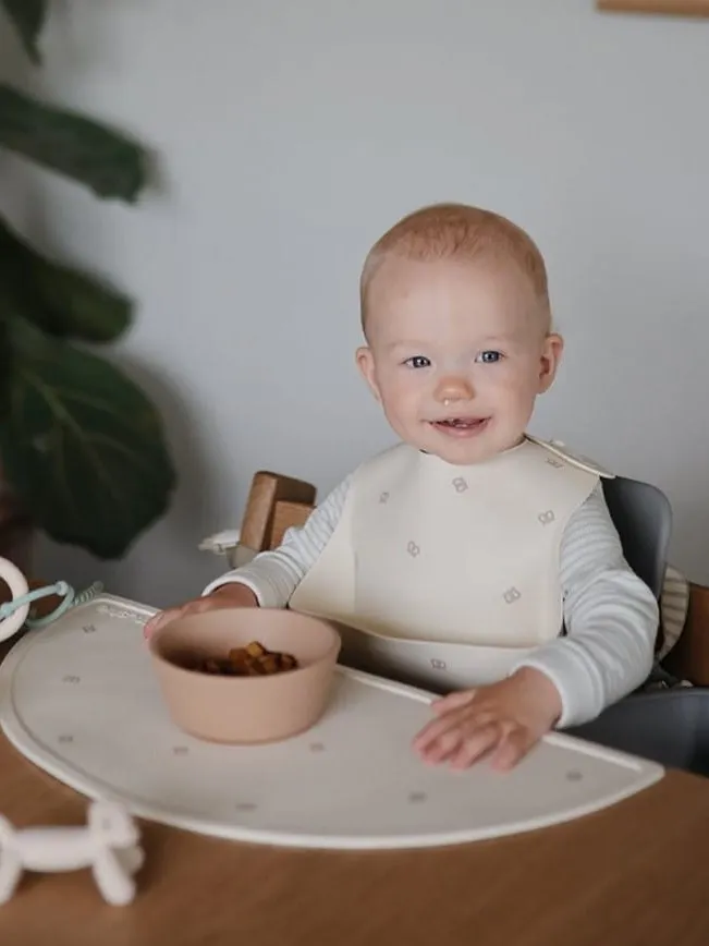 Mushie - śliniak silikonowy z kieszonką Pretzel