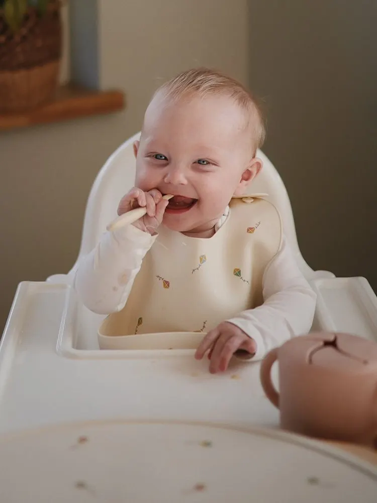 Mushie - śliniak silikonowy z kieszonką Kites