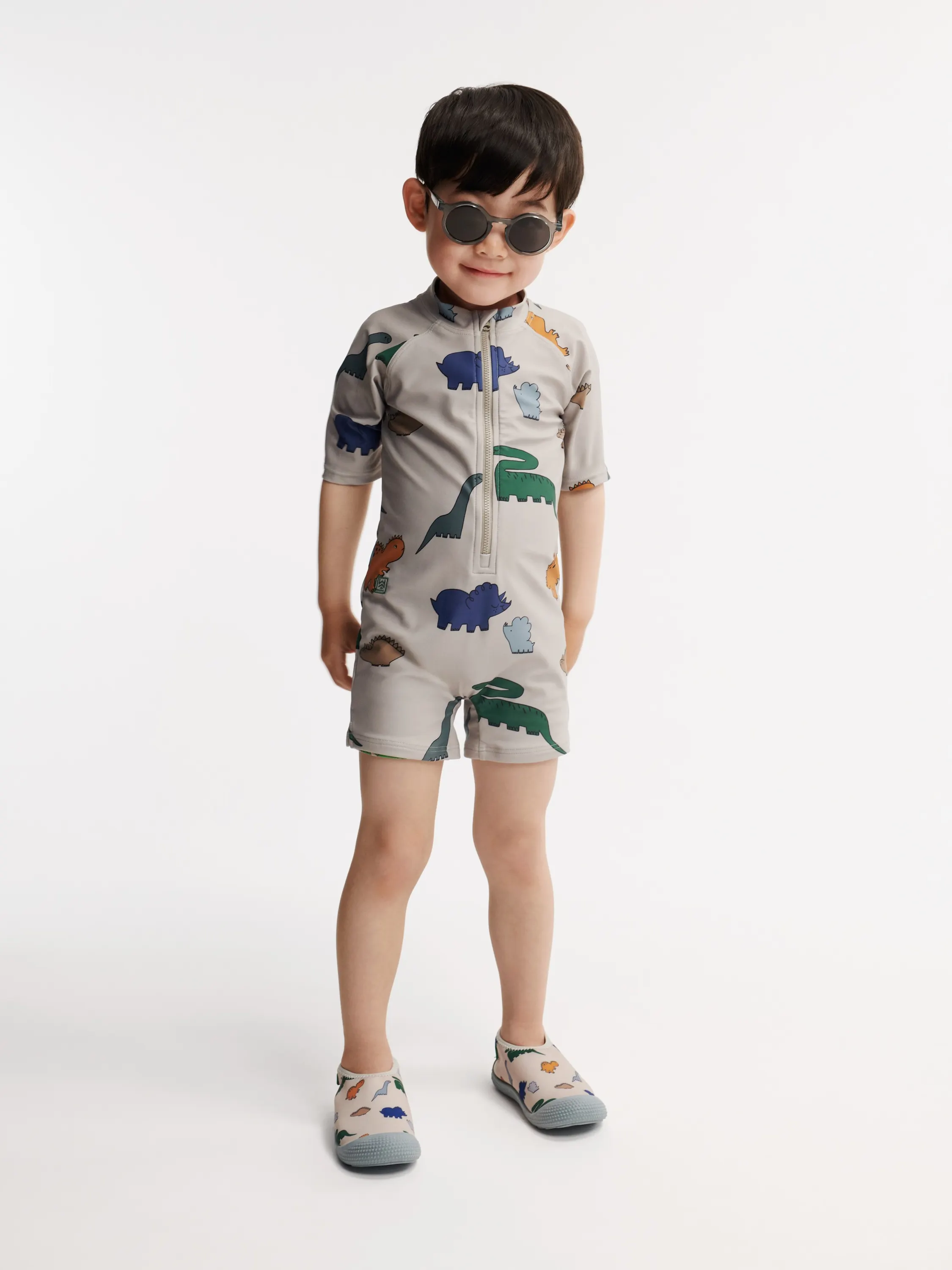 Liewood - kombinezon kąpielowy z krótkim rękawem UV Max Printed dinosaurs mist Liewood - kombinezon kąpielowy z krótkim rękawem UV Max Printed dinosaurs mist