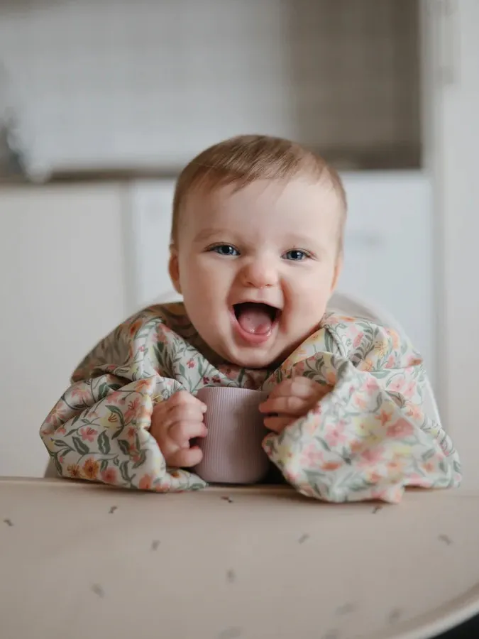 Mushie - śliniak wodoodporny z długim rękawem i kieszonką Pastel Blooms